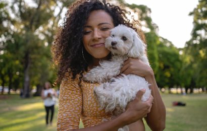 young-lady-cuddling-a-small-white-dog young-lady-cuddling-a-small-white-dog