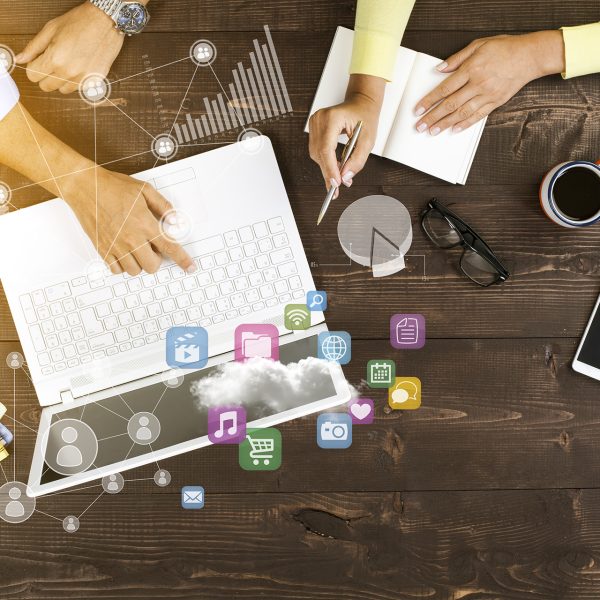 Two people working together on laptop at office with technological pattern